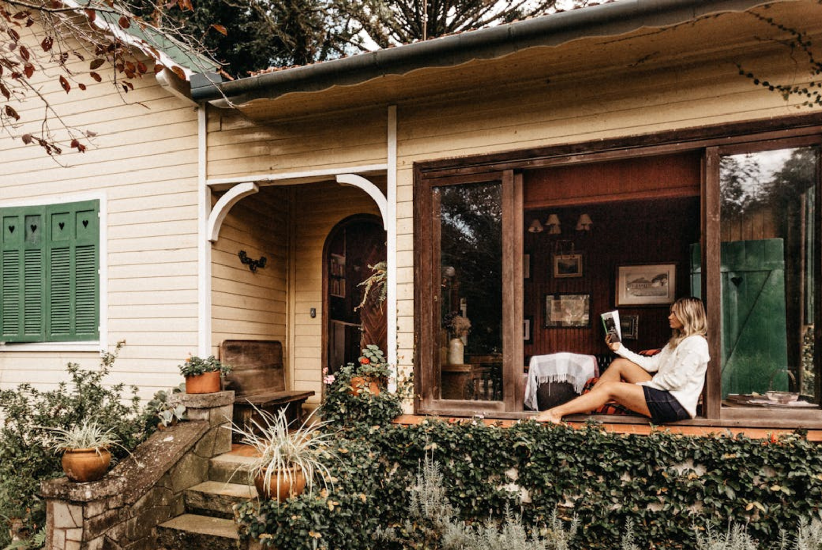 Mujer sentada en la ventana leyendo.